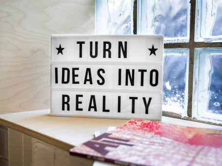 Leuchtkasten mit der Aufschrift ‚Turn Ideas into Reality‘ – Symbol für Umsetzungskraft, Innovation und kreative Transformation.